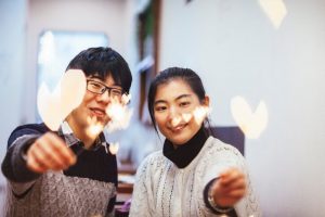 Young Asian couple with sparklers representing Ignite Faith Niagara Anti-Racism, Diversity, Inclusion, and Equity Work