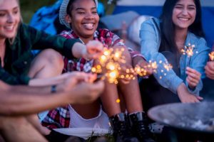 Young people with sparklers near camp fire representing Ignite Faith Niagara Canterbury Hills Camp